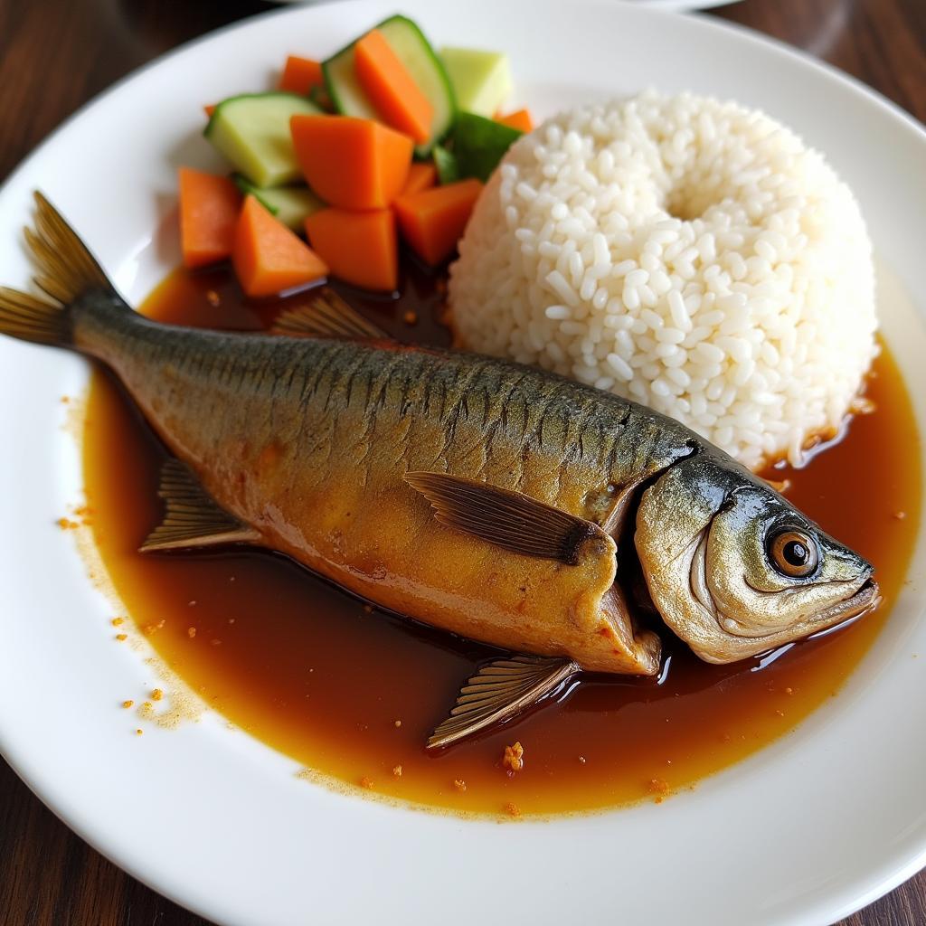 Cá nục kho mật mía được trình bày đẹp mắt trong đĩa, ăn kèm với cơm trắng và rau luộc